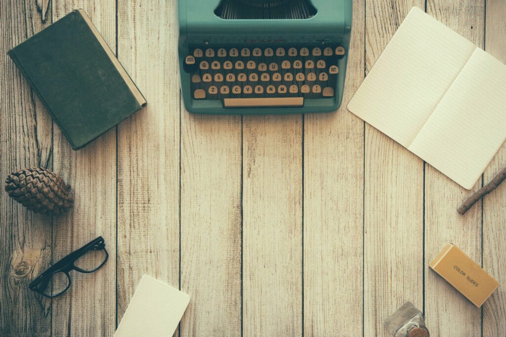 typewriter, notebook, book, and other writing supplies
