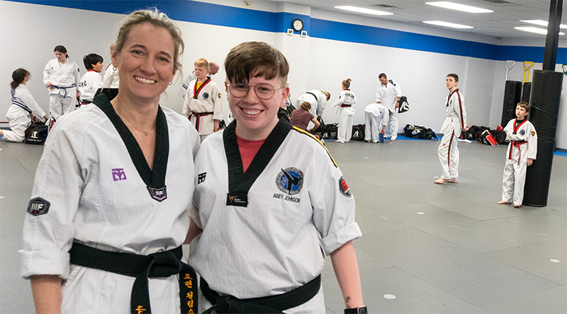 Master Phillips and coach Abby posing for photograph at Advantage Martial Arts in Kearney, Missouri. 