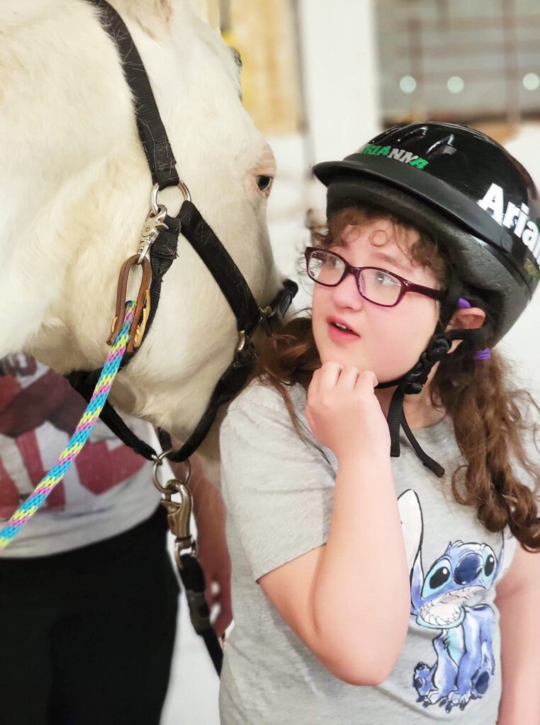 Photograph of a girl and a white horse at the Northland Therapeutic Riding Center in Kearney, Missouri. 