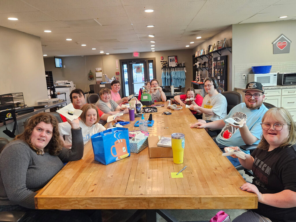 Fulfillment House associates sitting at long table. 