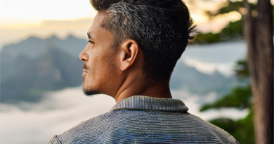 AI image of man staring into the distance with a mountain range and tree in background.