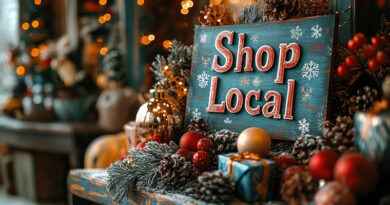 Sign sitting on shelf with Christmas ornaments that says "Shop Local"